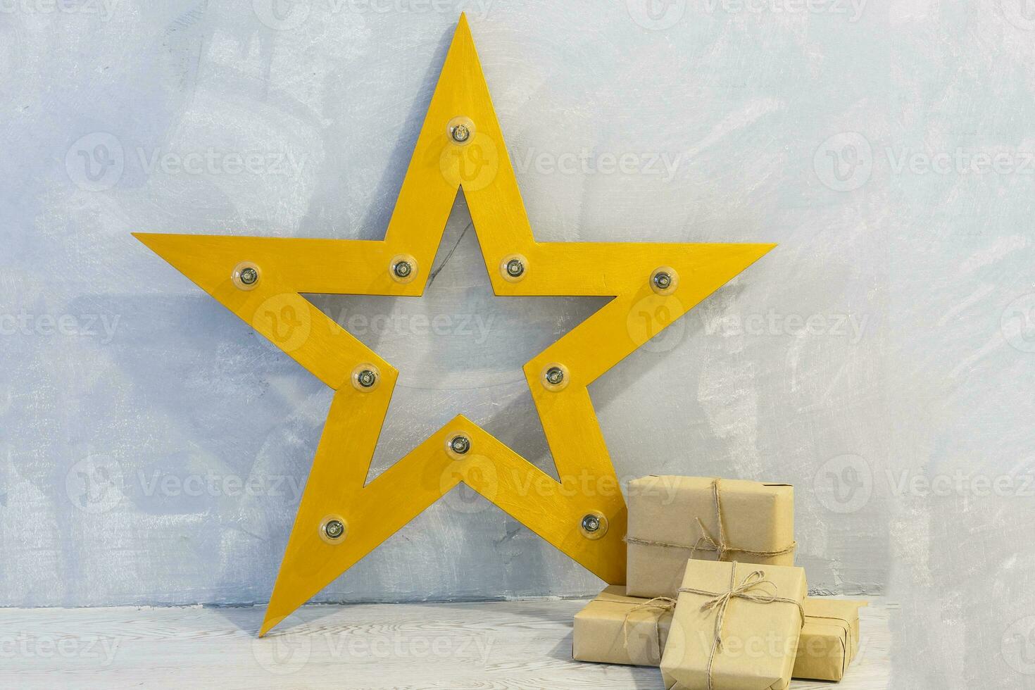 Gift box wrapped in craft paper with gold ribbon and stars on gray stone photo