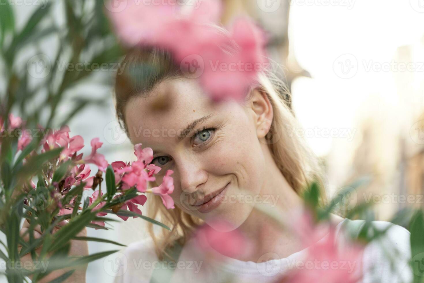 retrato de joven mujer con rosado adelfa flores foto