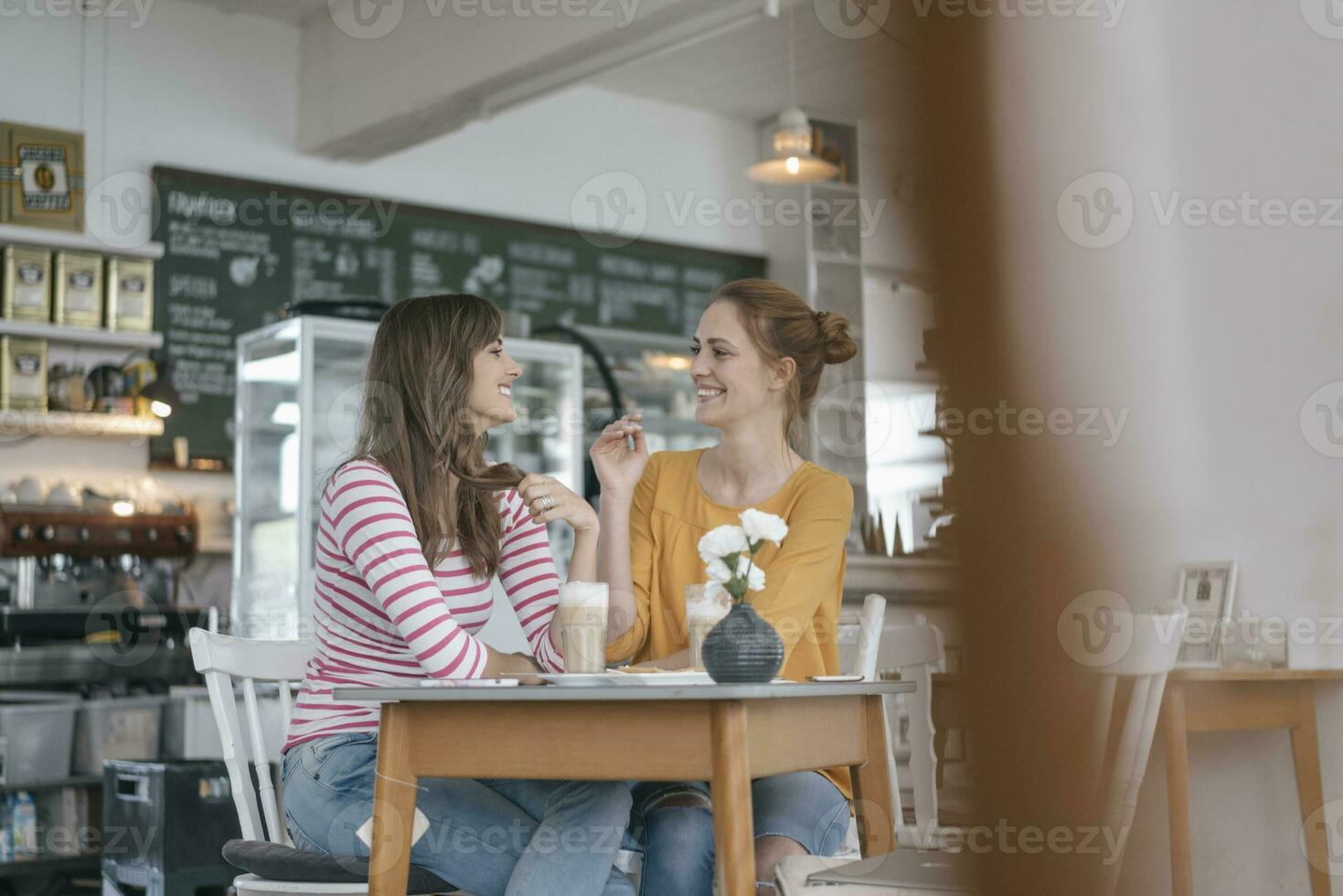 Two girlfriends meeting in a coffee shop, talking photo