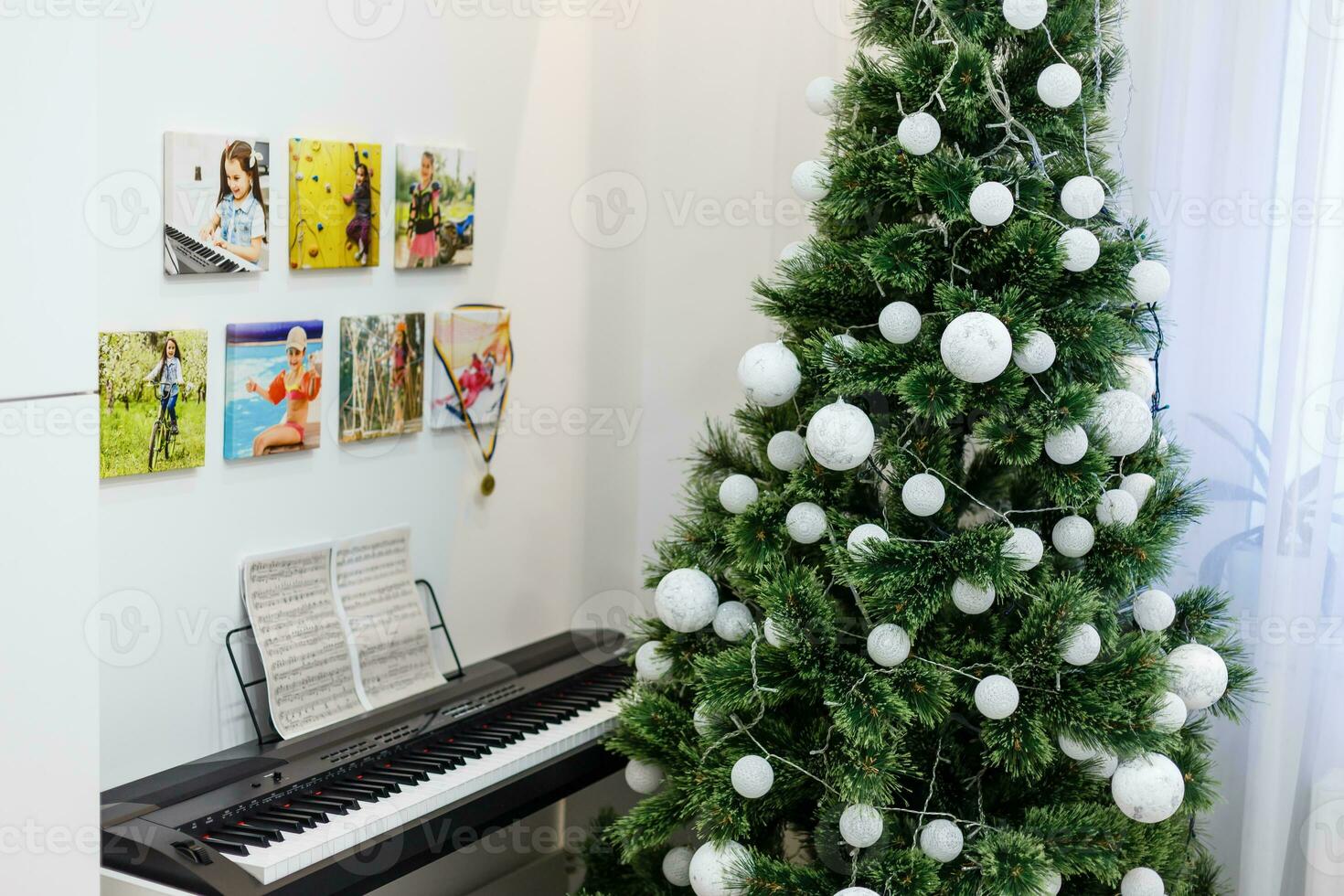 Some photos hanging on a rope, white wall background, next is an electronic piano, Christmas