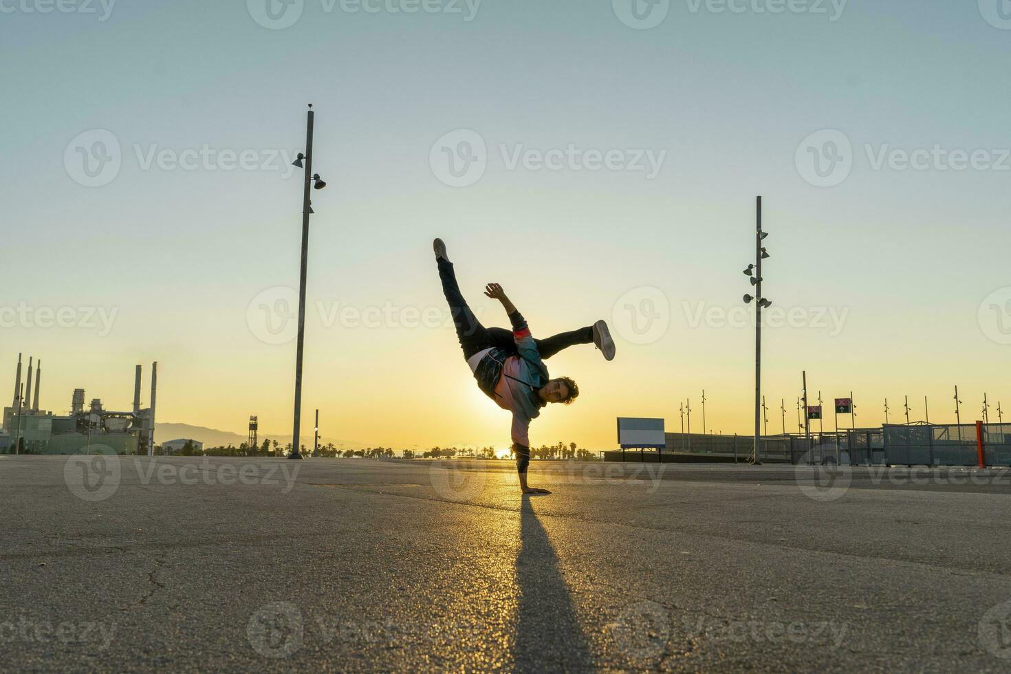 acróbata haciendo parada de manos en el ciudad a amanecer foto