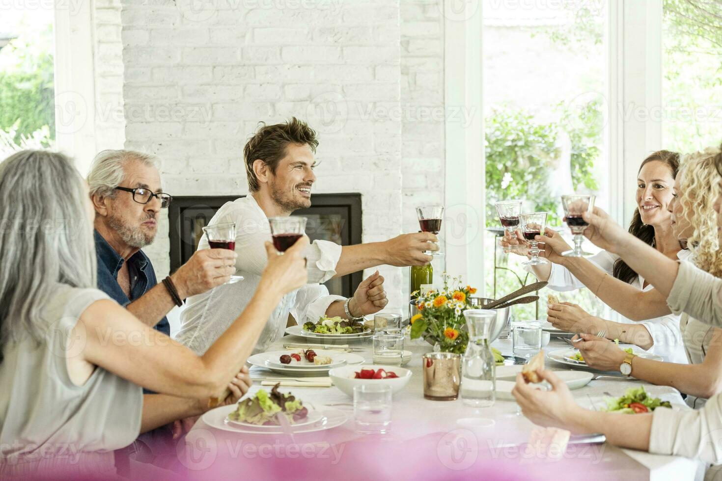 Happy family celebrating together, clinking glasses photo