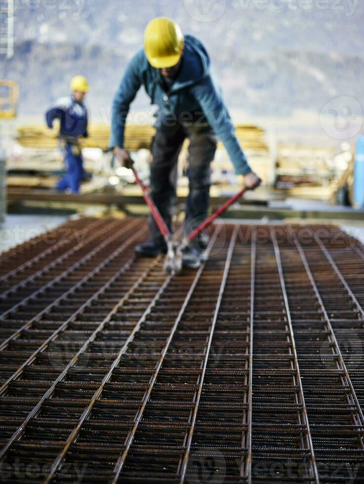 Construction worker cutting iron with plier photo