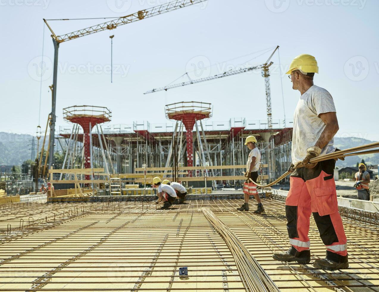 Workers on construction site preparing iron rods photo