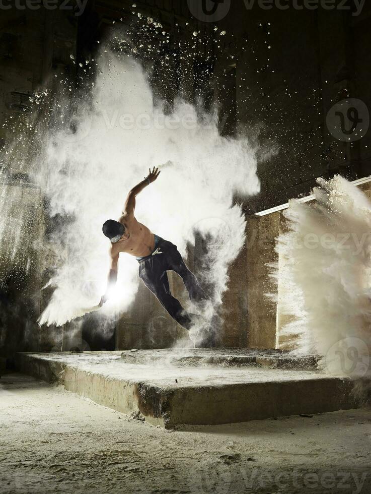 hombre saltando en harina polvo nube durante de funcionamiento libre ejercicio foto