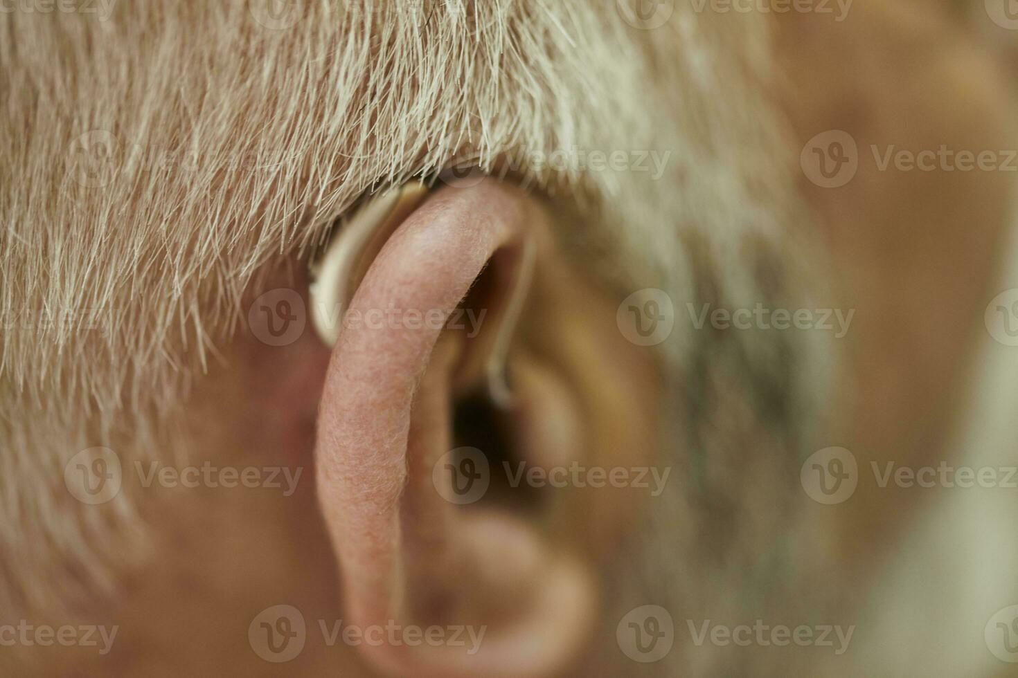 Close-up of senior man with hearing aid photo