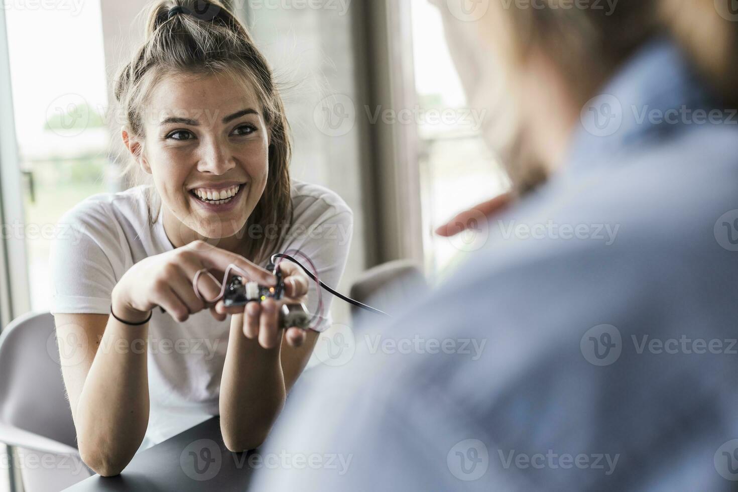 Happy young woman and man working on computer equipment in office photo
