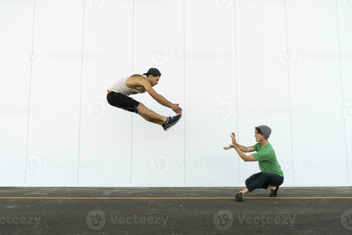 Two acrobats doing tricks together, jumping mid-air photo