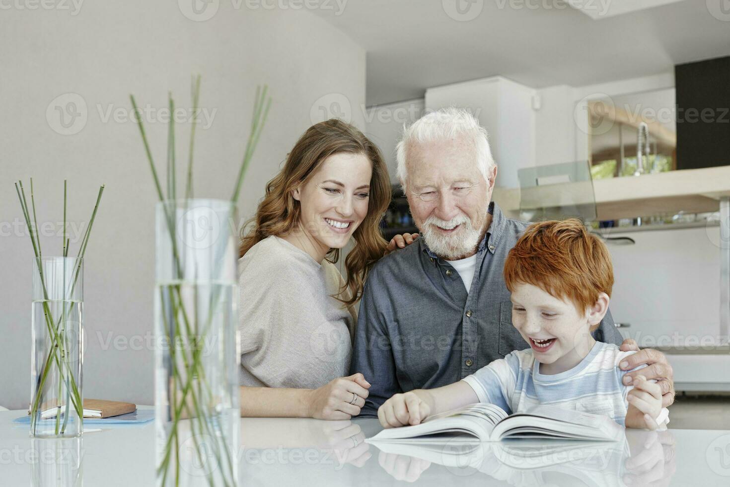 Happy grandfather, mother and son reading book in a villa photo
