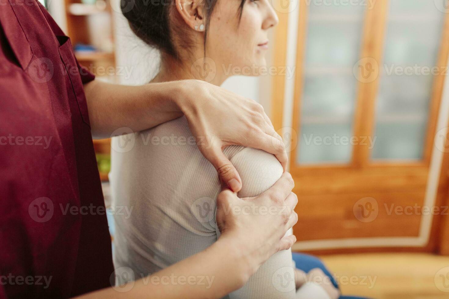 Physiotherapist massaging woman shoulder photo