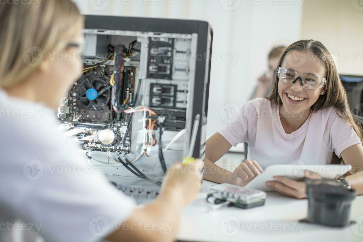 contento Adolescente muchachas montaje computadora en clase foto