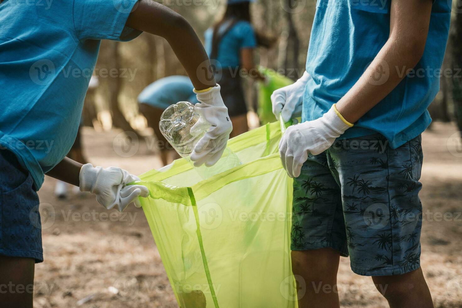 Close-up of volunteering children collecting garbage in a park photo