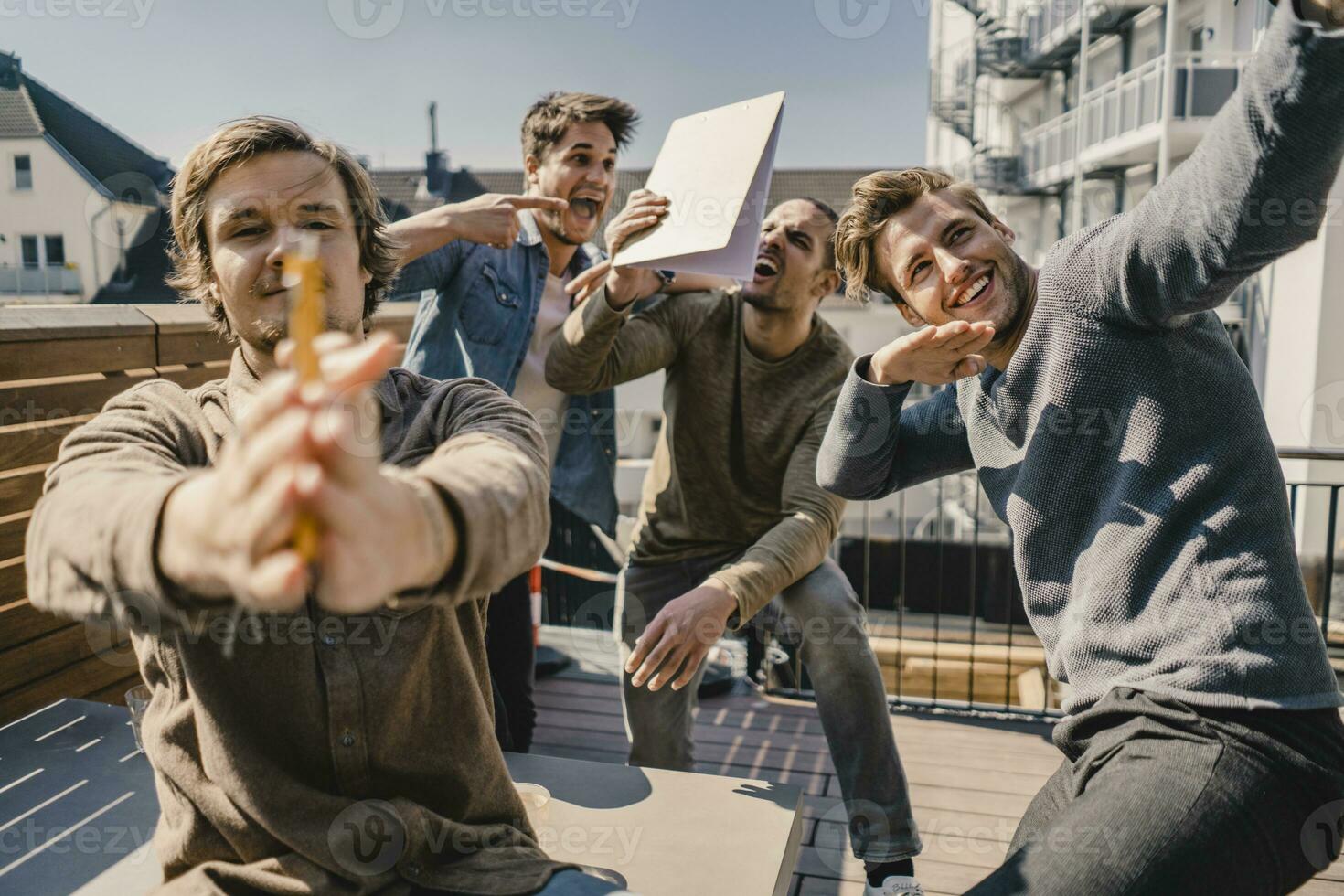 joven empresarios teniendo divertido en un balcón, celebrando éxito foto