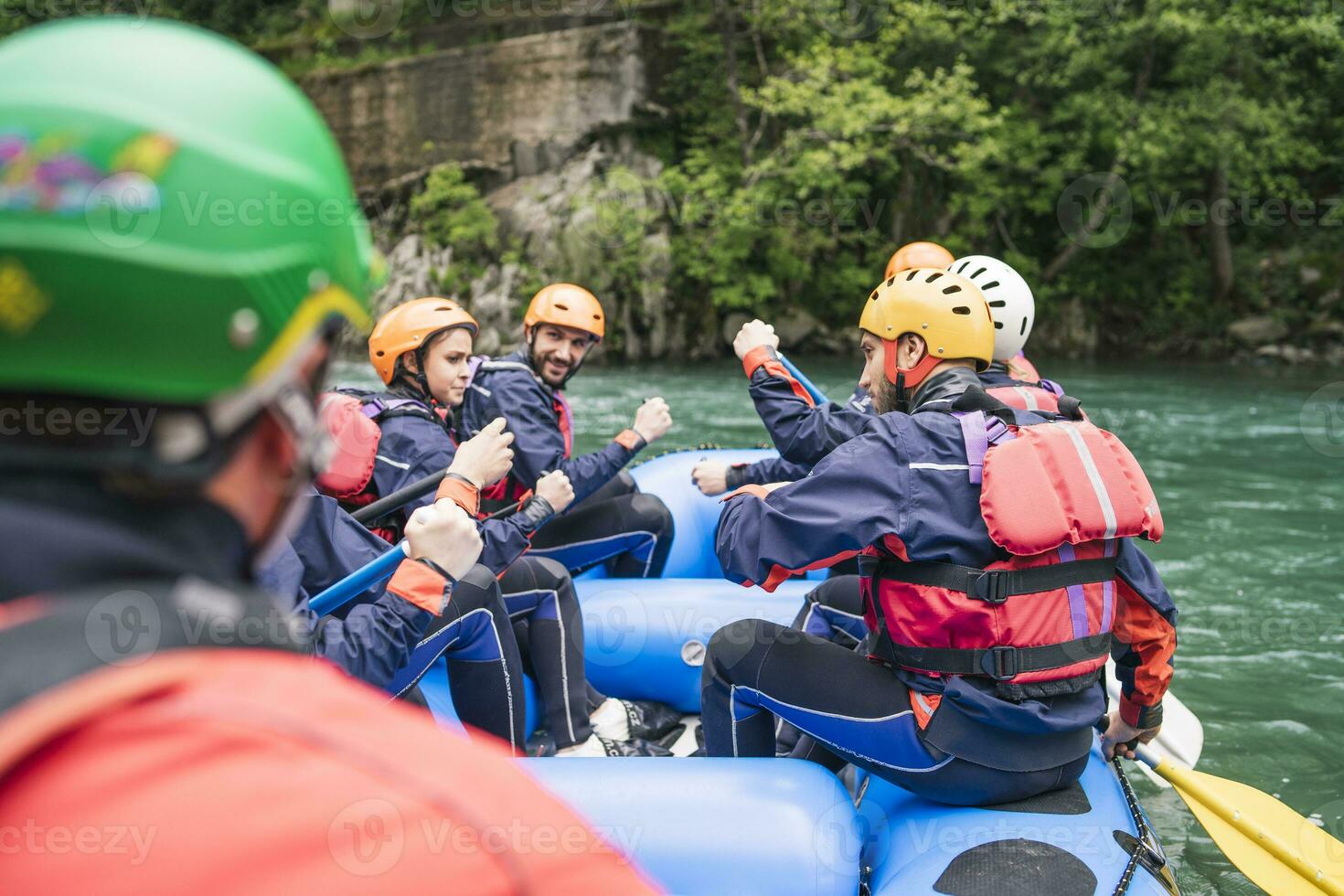 Group of people rafting in rubber dinghy on a river photo