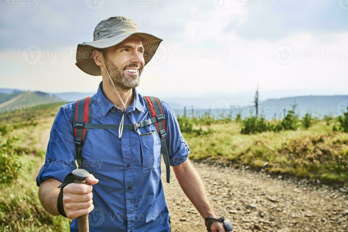 Portrait of smiling man hiking in the mountains photo