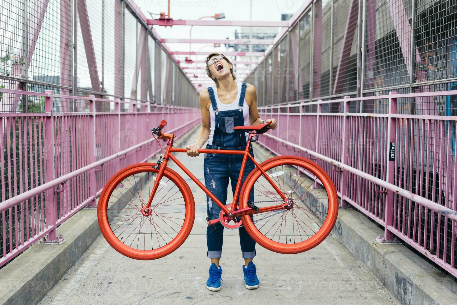 USA, New York City, Williamsburg, woman with red racing cycle on Williamsburg Bridge photo