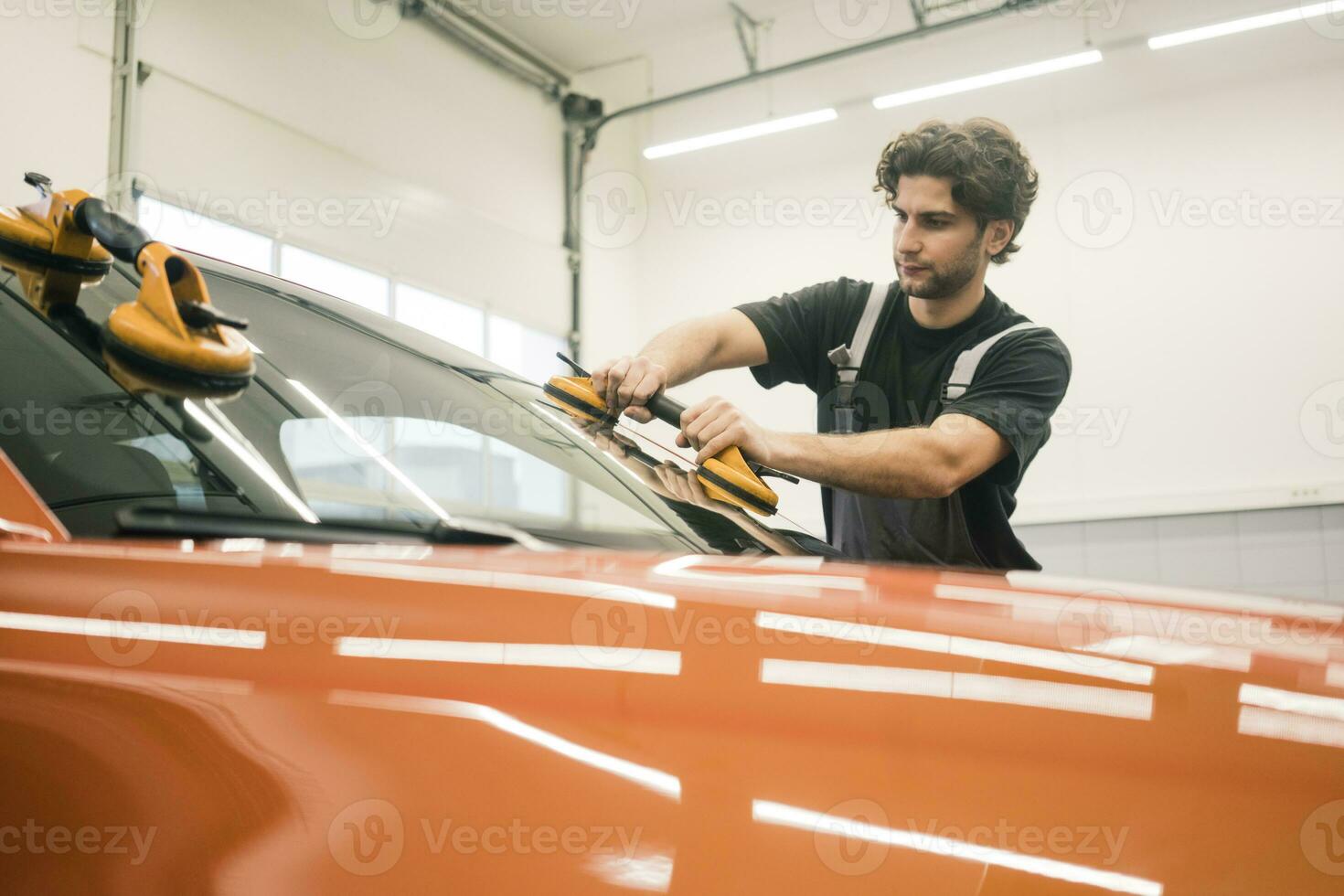 Car mechanic in a workshop changing car window photo