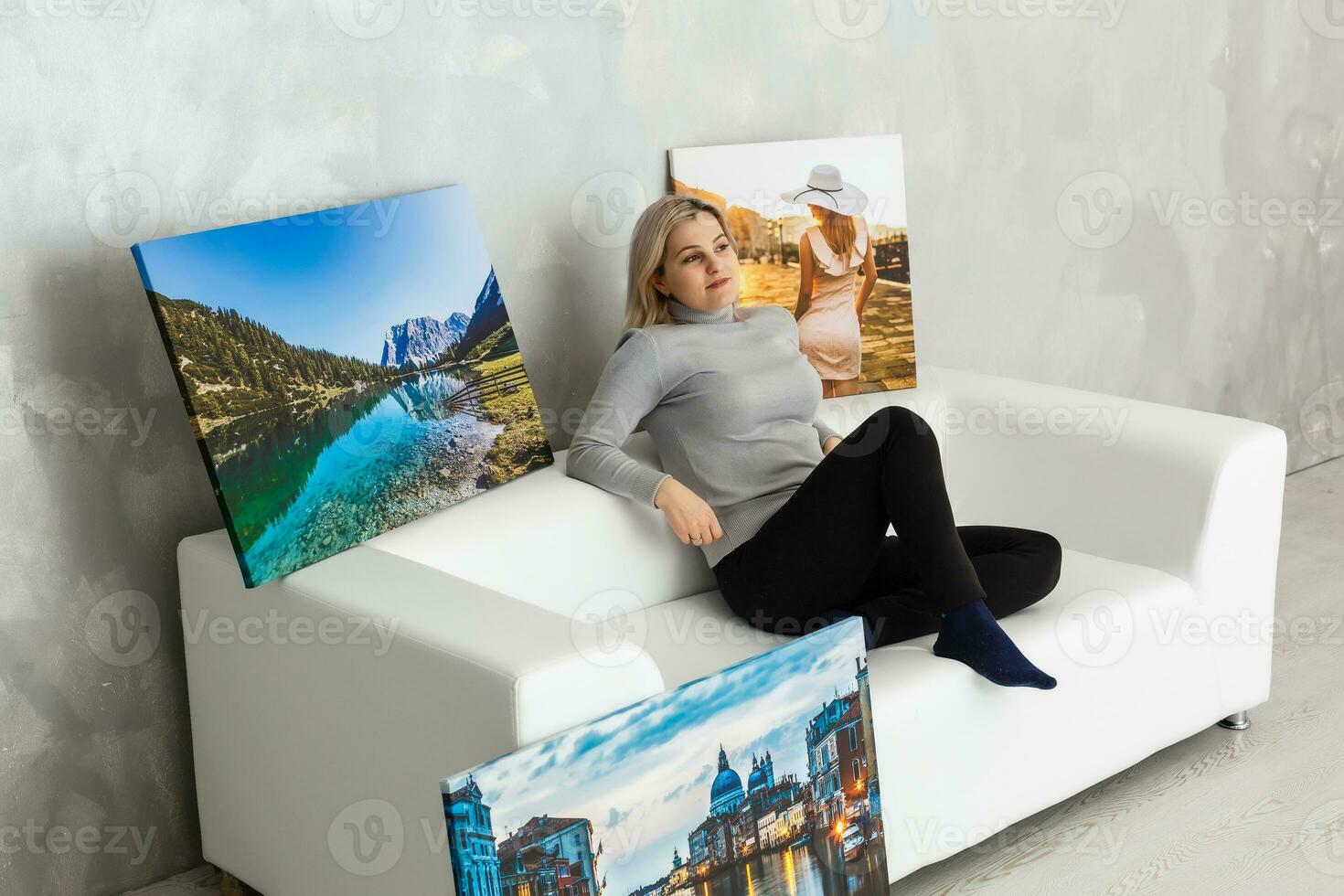 Young girl holds photo canvas at home on the couch