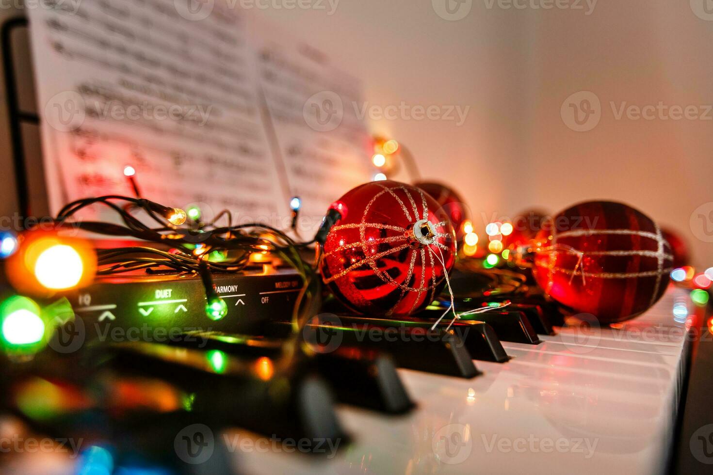 Piano keys decorated with decoration lights and red ball, close up photo