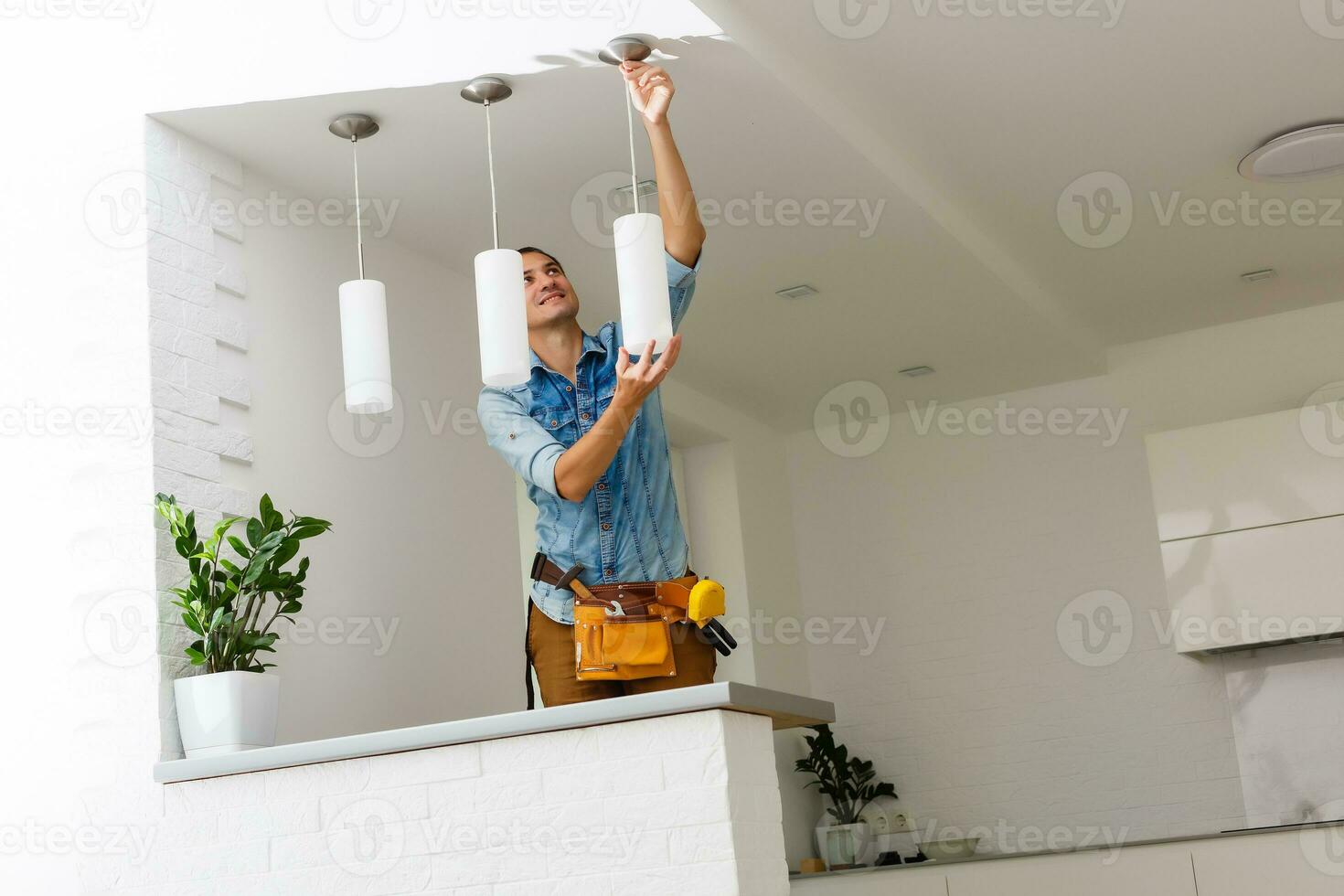 electricista es instalando y conectando un lámpara a un techo. foto