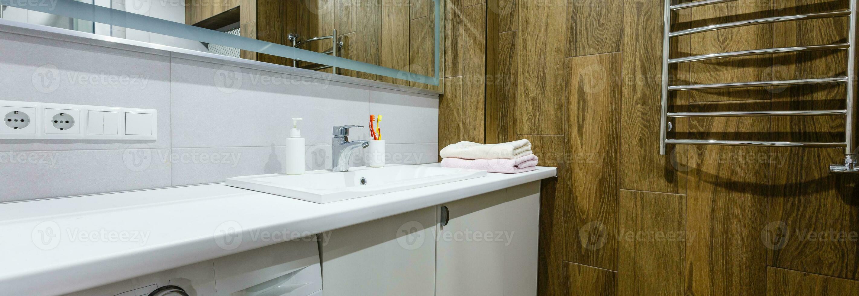 Spacious bathroom in gray tones with heated floors, walk-in shower, double sink vanity and skylights photo