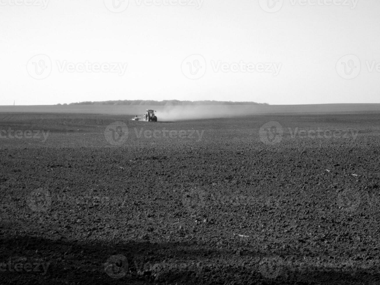 Plowed field by tractor in black soil on open countryside nature photo