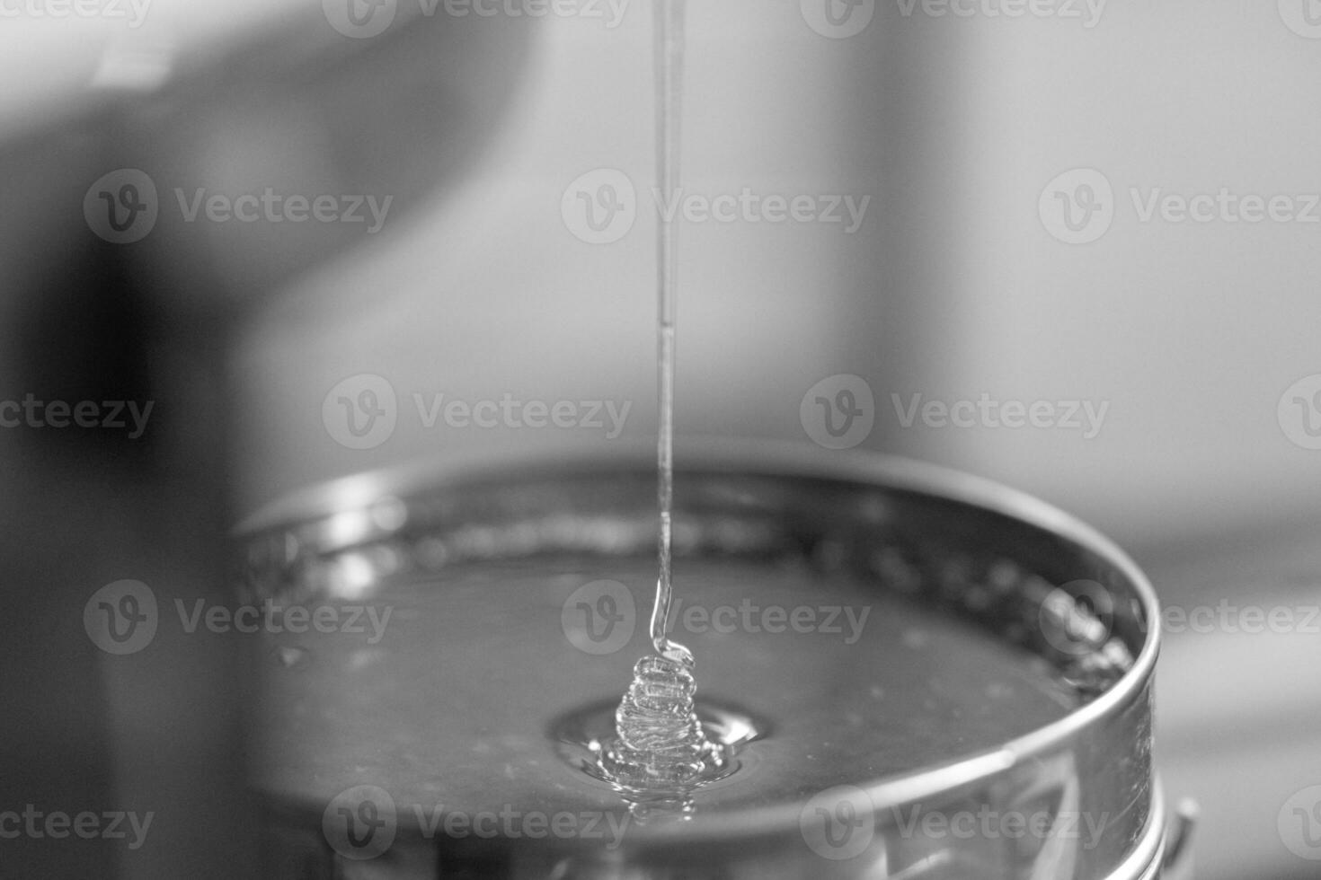 Drop of bee honey drip from hexagonal honeycombs photo