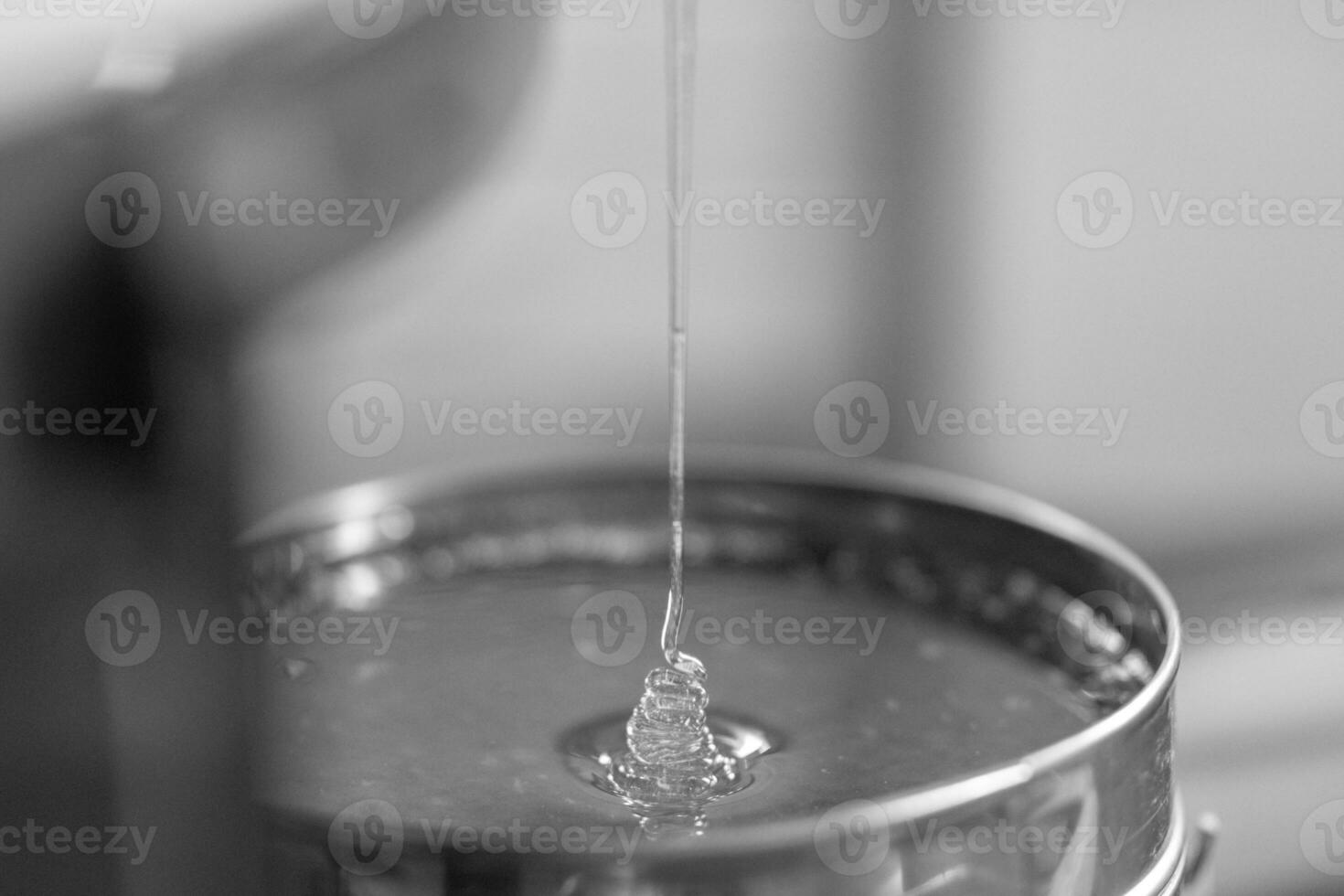 Drop of bee honey drip from hexagonal honeycombs photo