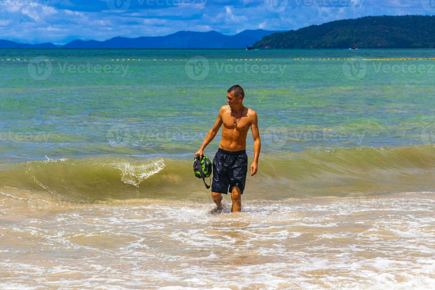 Male handsome tourist swimming having fun Railay West Beach Thailand. photo