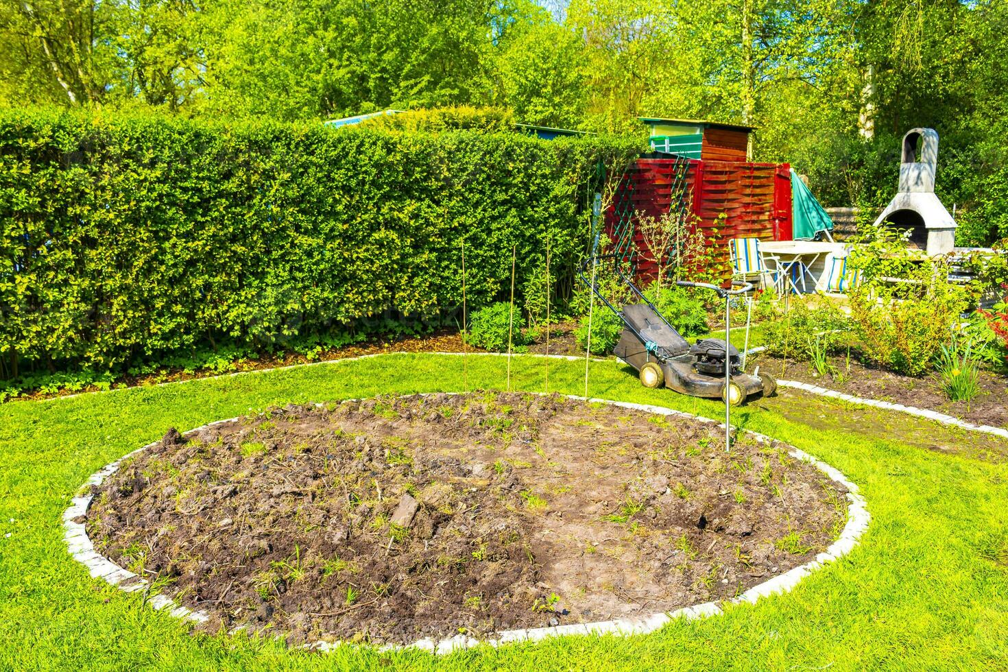 Garden with round beds soil young sprouts plants in Germany. photo