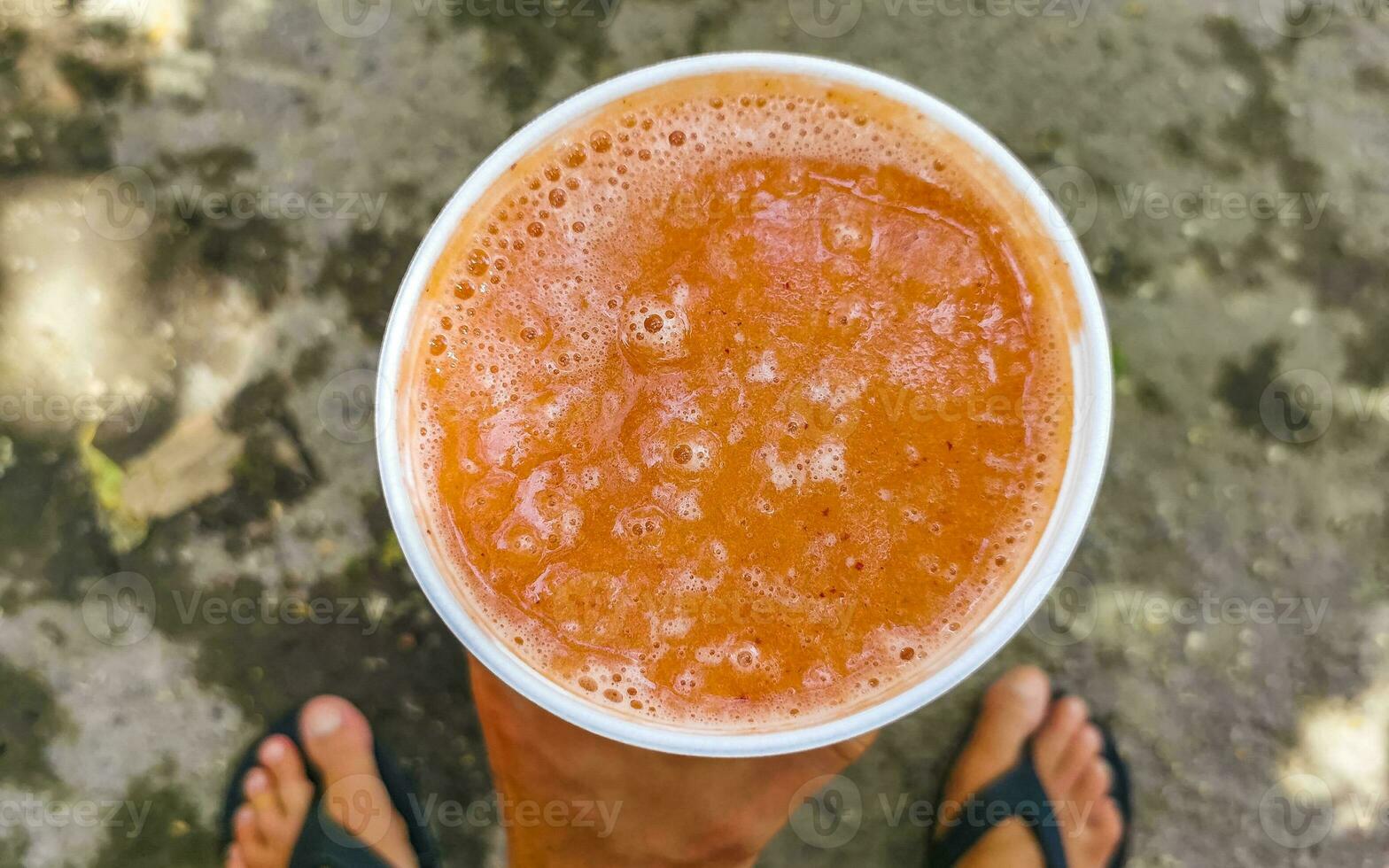 Orange multi vitamin fruit juice in take away cup Mexico. photo