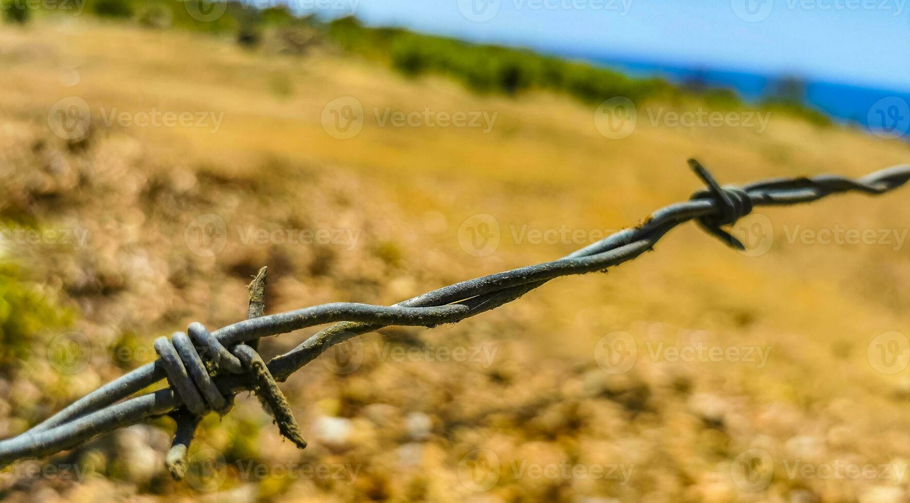 Nature beach and desert behind barbed wire fence and chains. photo