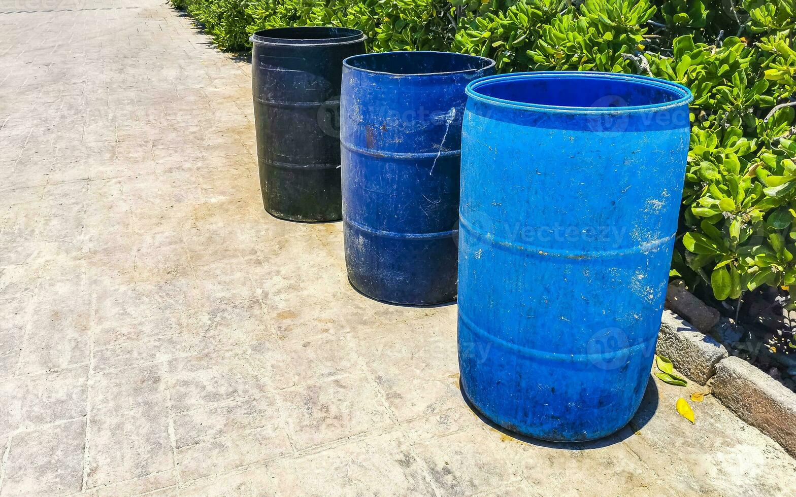 Blue trash garbage cans dirty street Playa del Carmen Mexico. photo