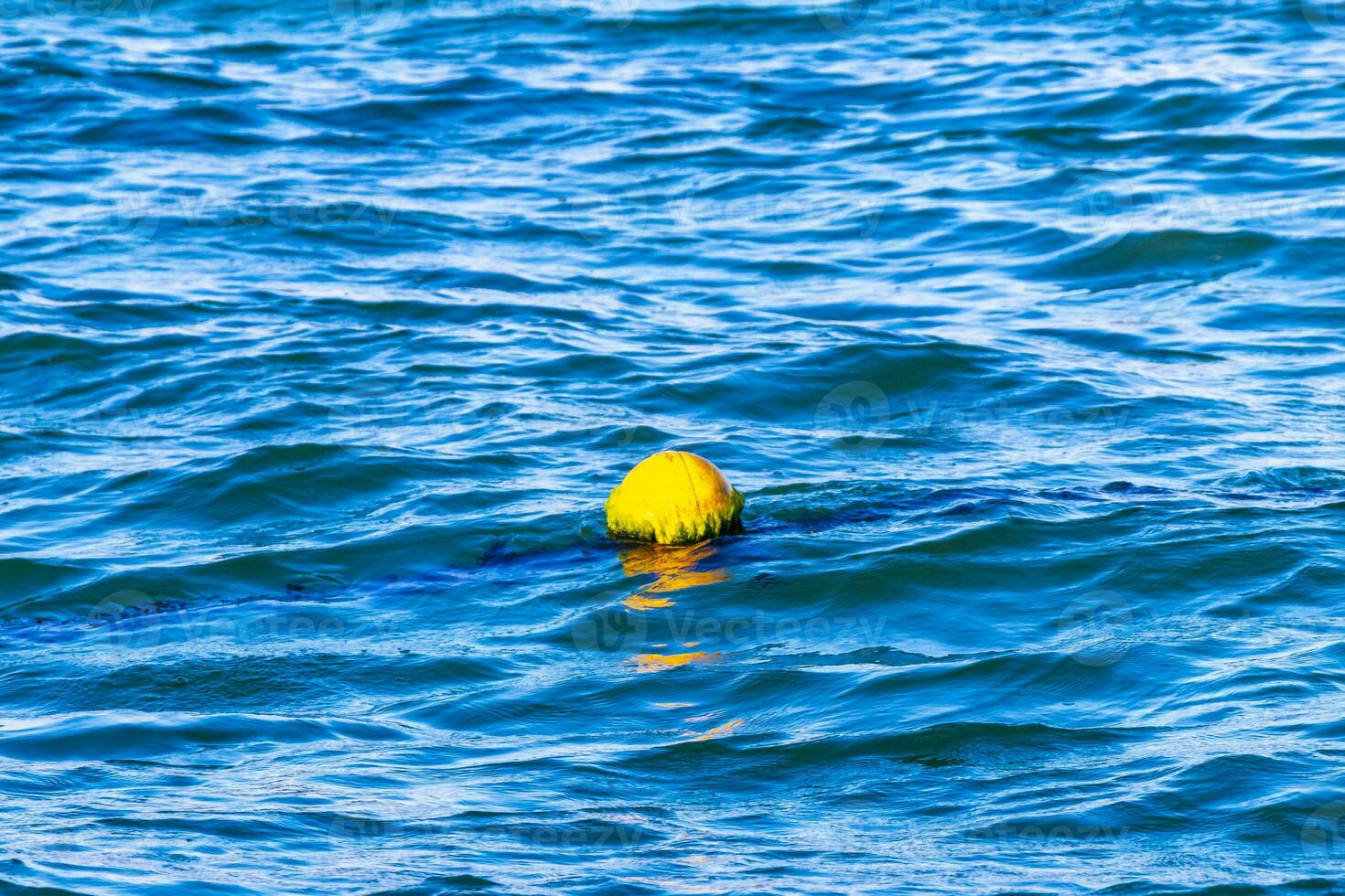 Blue water waves ocean with buoy buoys ropes nets Mexico. photo