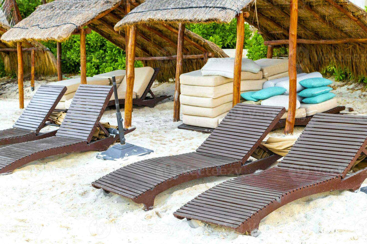 Palapa thatched roofs palms parasols sun loungers beach resort Mexico. photo