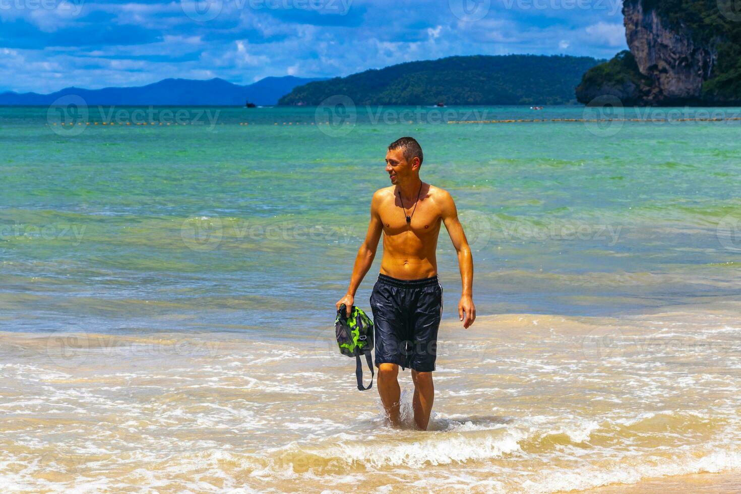 Male handsome tourist swimming having fun Railay West Beach Thailand. photo