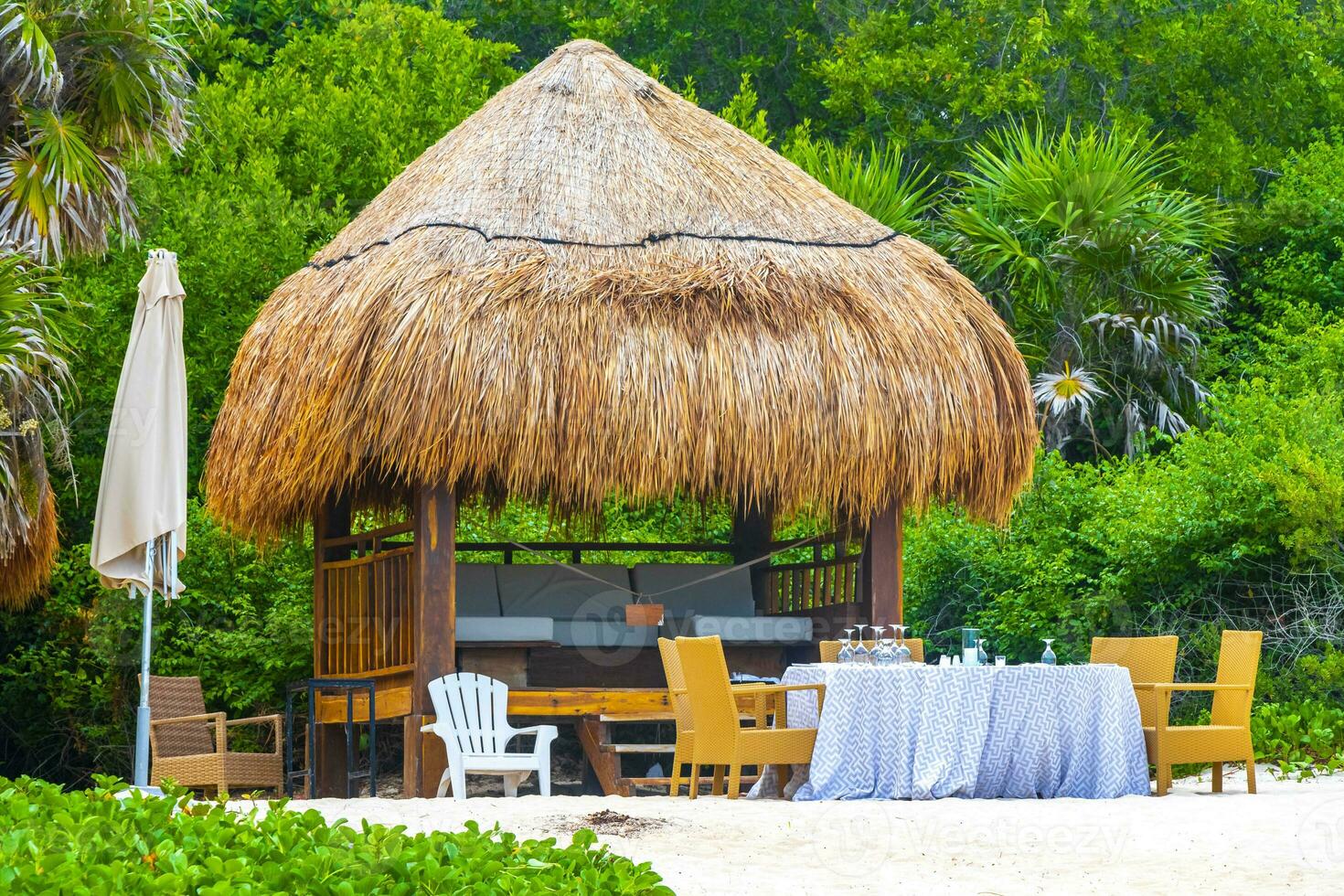 Palapa thatched roofs palms parasols sun loungers beach resort Mexico. photo