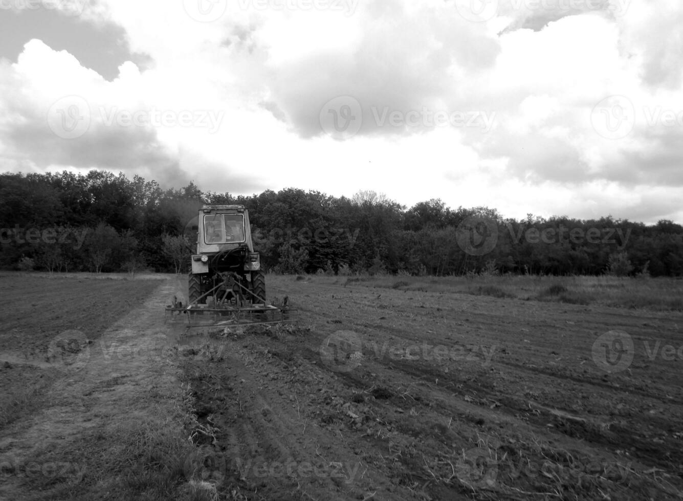 Plowed field by tractor in black soil on open countryside nature photo