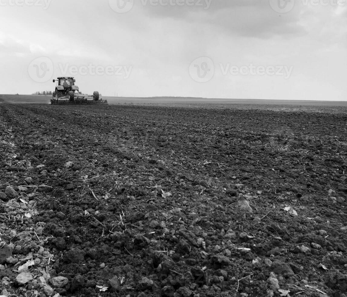 Plowed field by tractor in black soil on open countryside nature photo