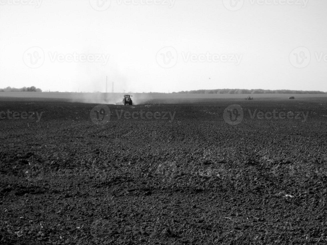 Plowed field by tractor in black soil on open countryside nature photo