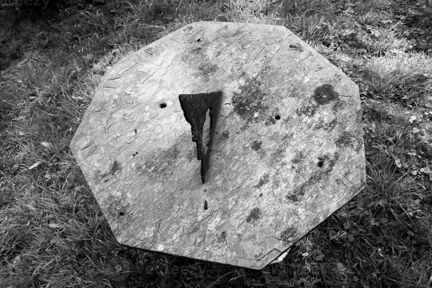 Un reloj de sol muy antiguo muestra el tiempo en un denso bosque de vegetación foto