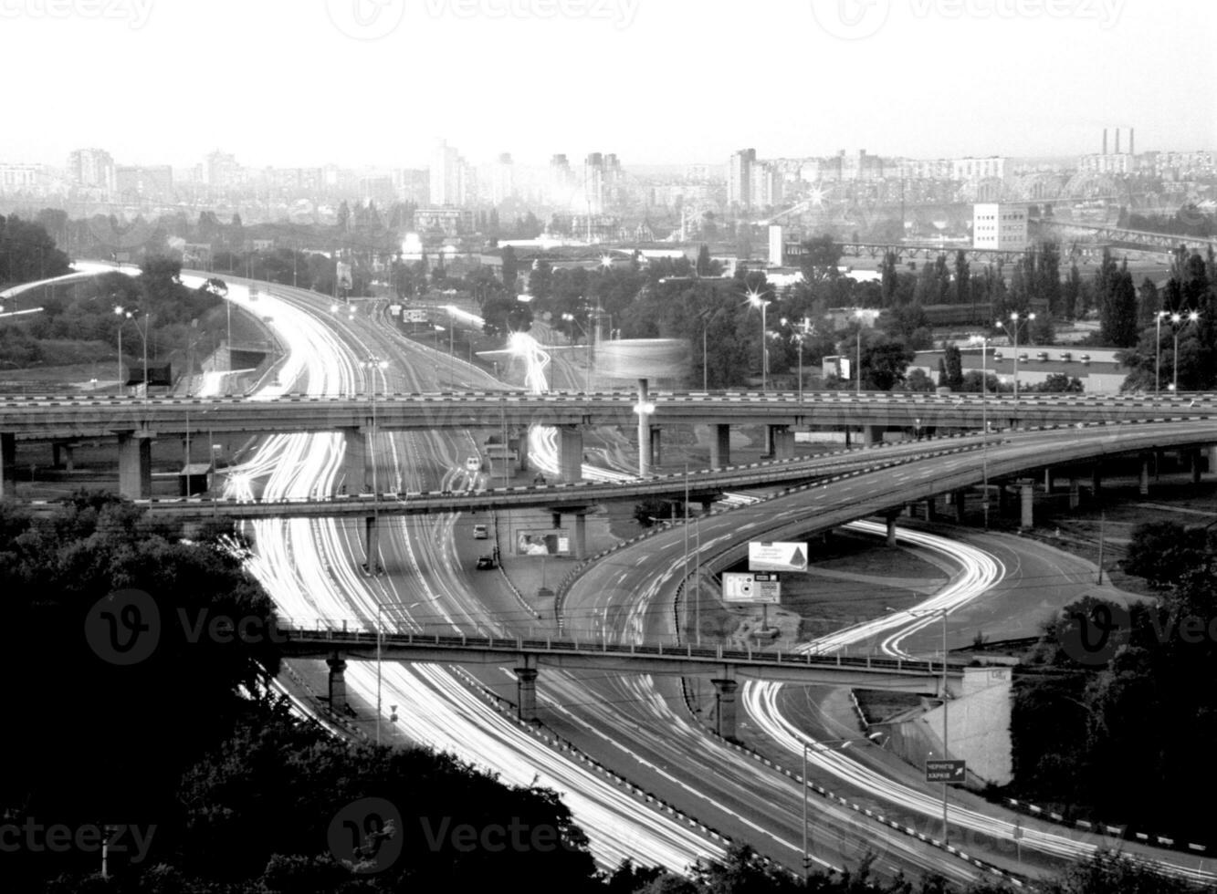 Cruce de carreteras en asfalto negro sobre naturaleza urbana abierta foto