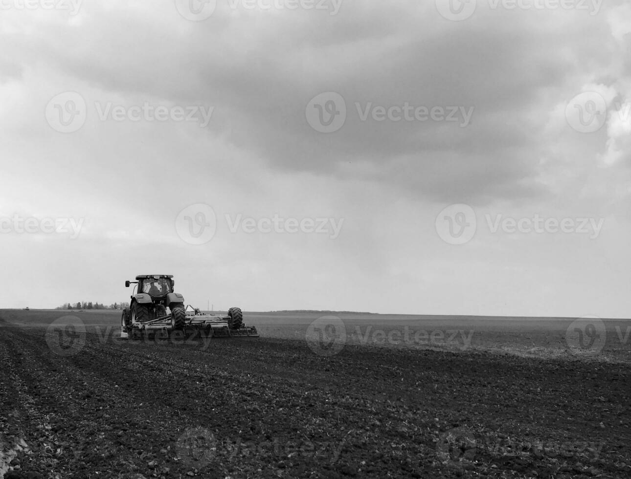 Plowed field by tractor in black soil on open countryside nature photo