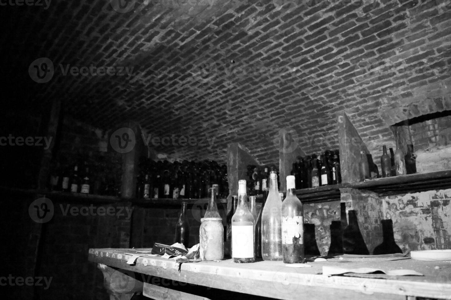 Very ancient bottles of wine lies in retro dark cellar photo