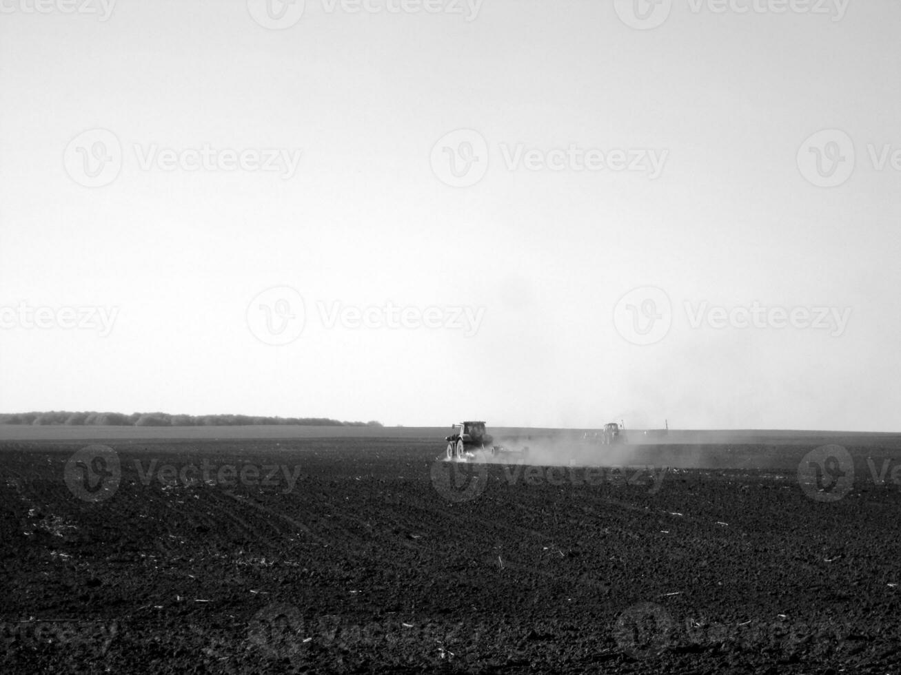 Plowed field by tractor in black soil on open countryside nature photo