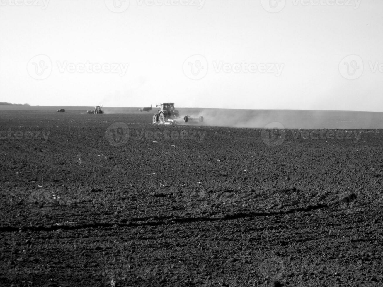 Plowed field by tractor in black soil on open countryside nature photo