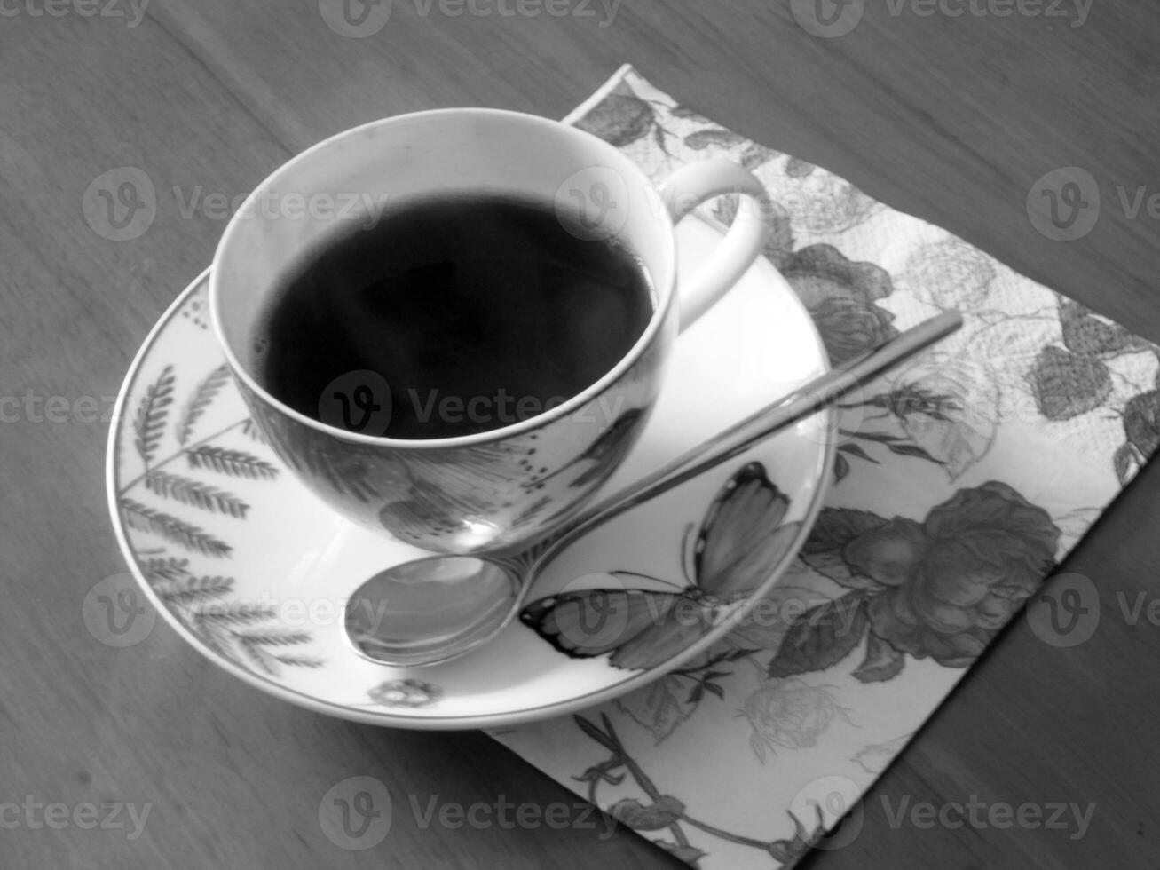 taza de café de belleza sobre una mesa de madera con café oscuro y sabroso foto