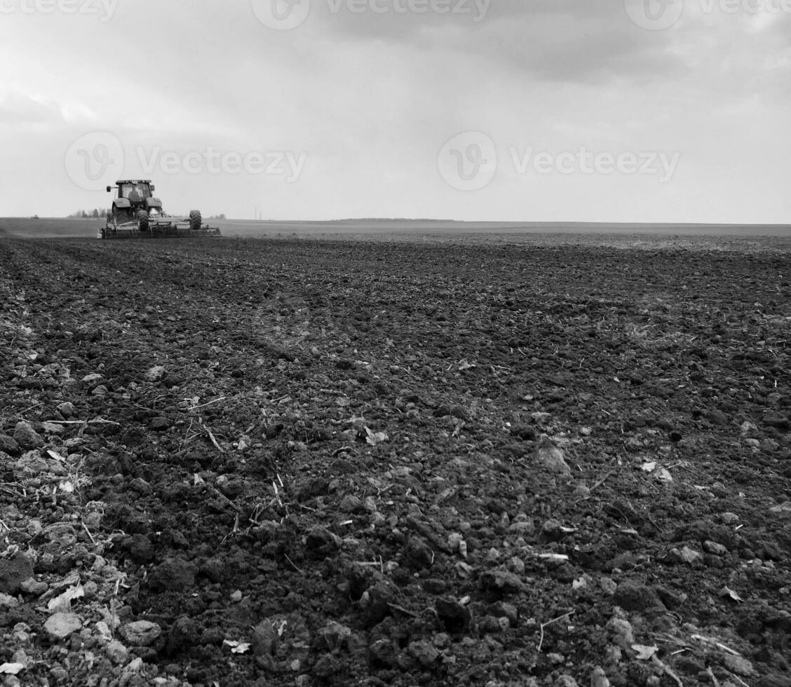 Plowed field by tractor in black soil on open countryside nature photo