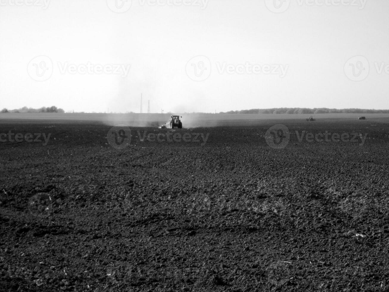 Plowed field by tractor in black soil on open countryside nature photo