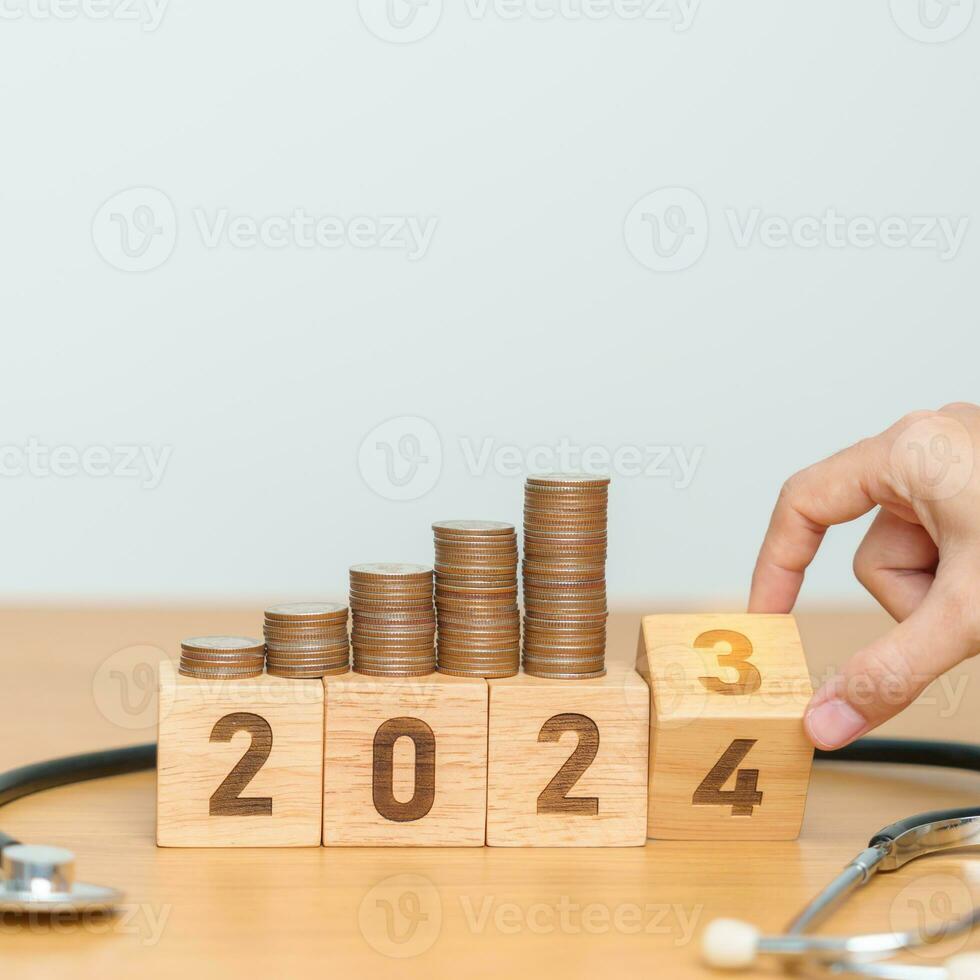 2024 contento nuevo año para salud cuidado con médico estetoscopio en mesa. dinero ahorro, meta, resolución, salud seguro, bienestar y médico concepto foto